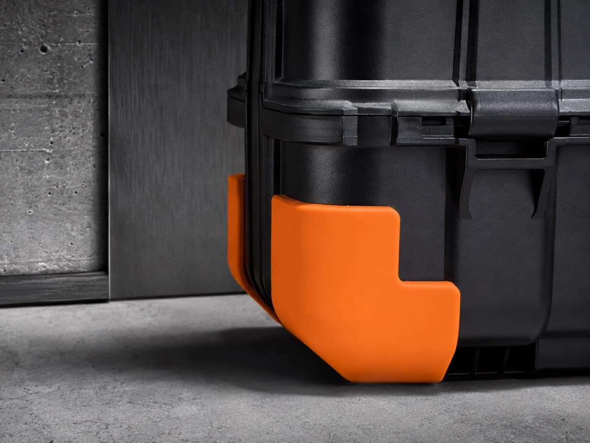 A moulded silicone corner guard fitted onto the bottom corner of a hard-shell case.